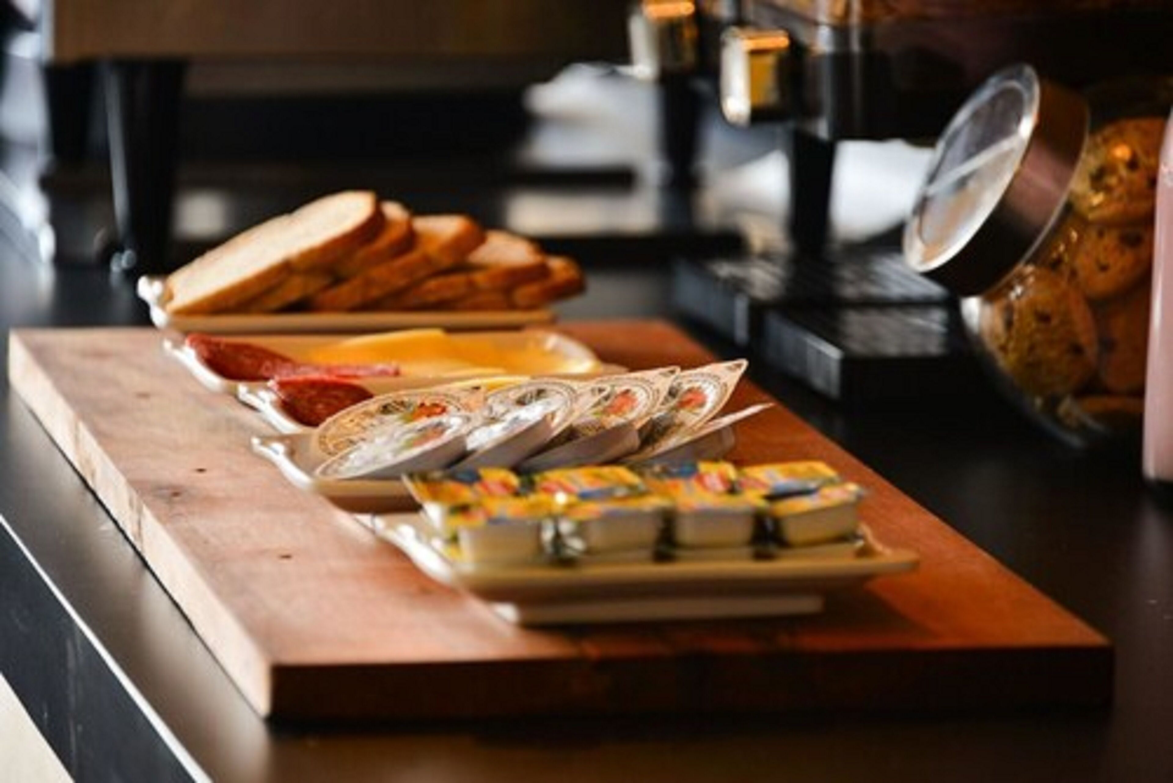 A breakfast buffet with various food items and a coffee machine in the background.