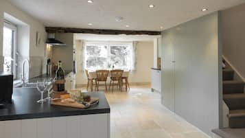 A kitchen with a dining area, a staircase, and a window with a view.