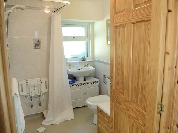 Ein Badezimmer mit Dusche, Waschbecken und Toilette.