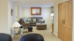 A living room with a sofa set, a glass coffee table, a lamp, and a wooden wardrobe. - 2 bedroom accommodation in Sleights, near Whitby (Sleights, near Whitby)