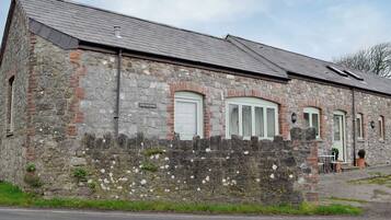 A stone building with a sign reading "The Old Byre."