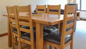 A wooden dining table surrounded by six chairs with black cushions. - Stable Cottage 5 - UKC3744 (Foxley, near Fakenham)