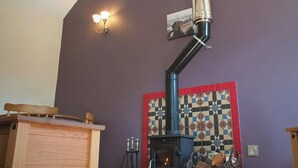 A room with a wood-burning stove, a table, and a chair. - 1 bedroom accommodation in Fitling, near Hull (Fitling, near Hull)