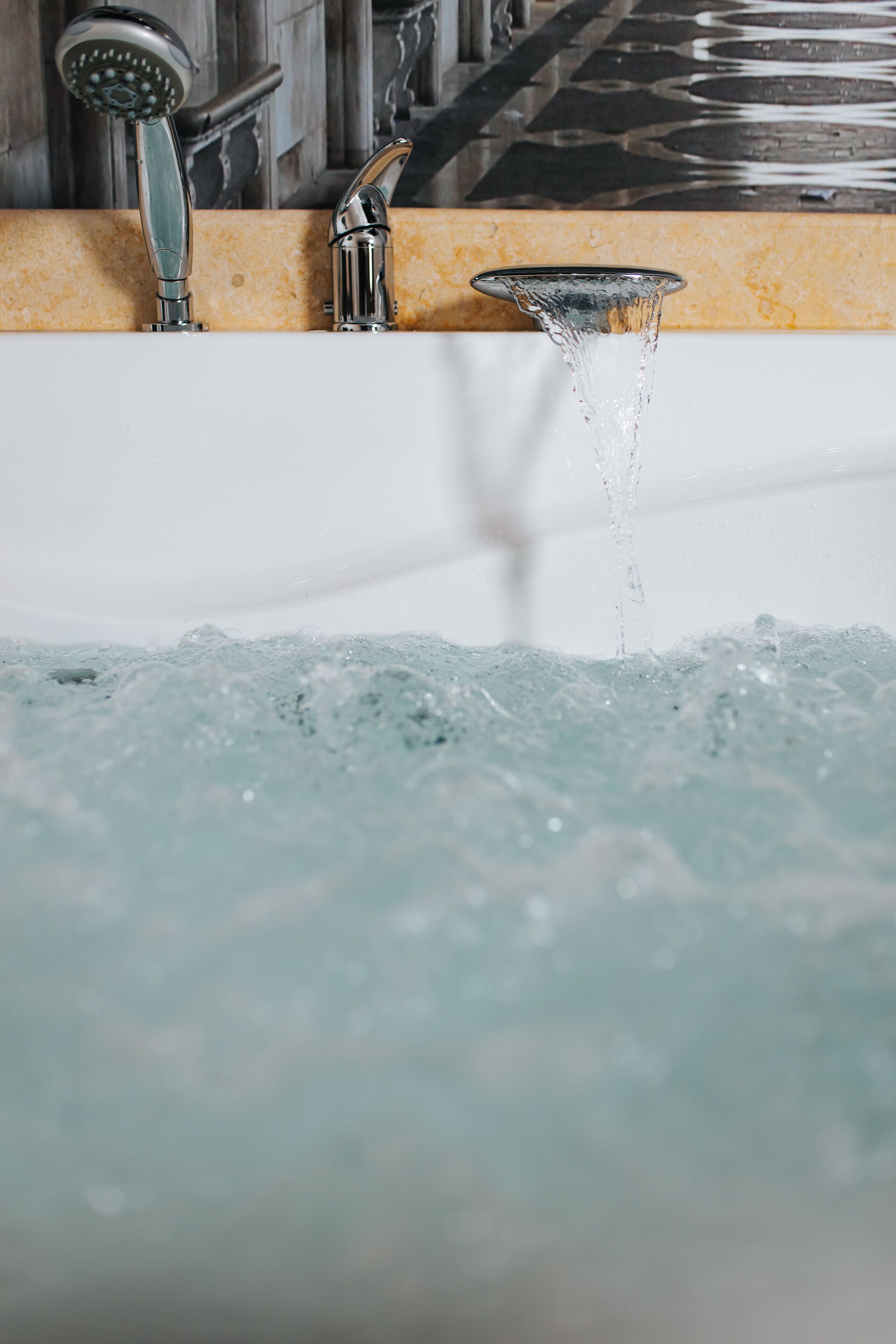 A bathroom with a bathtub, a showerhead, and a faucet.