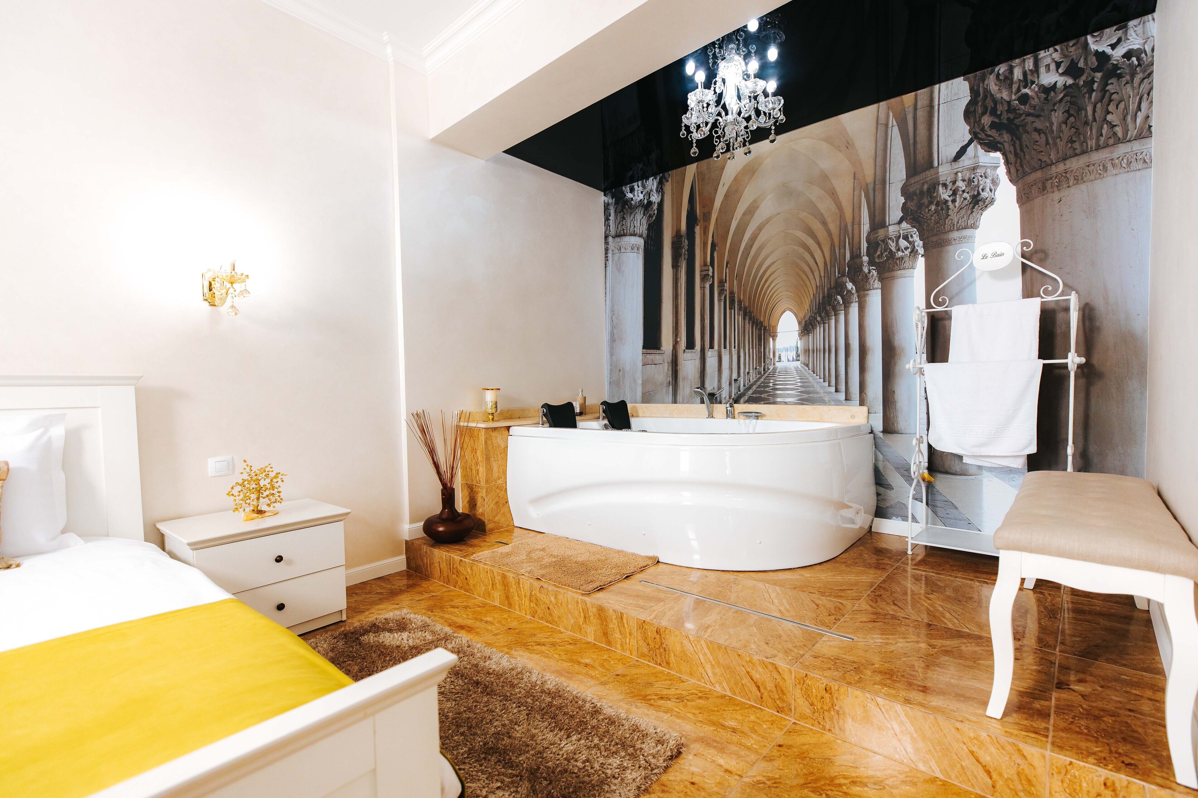 A modern bathroom with a large bathtub, a vanity, and a bench.