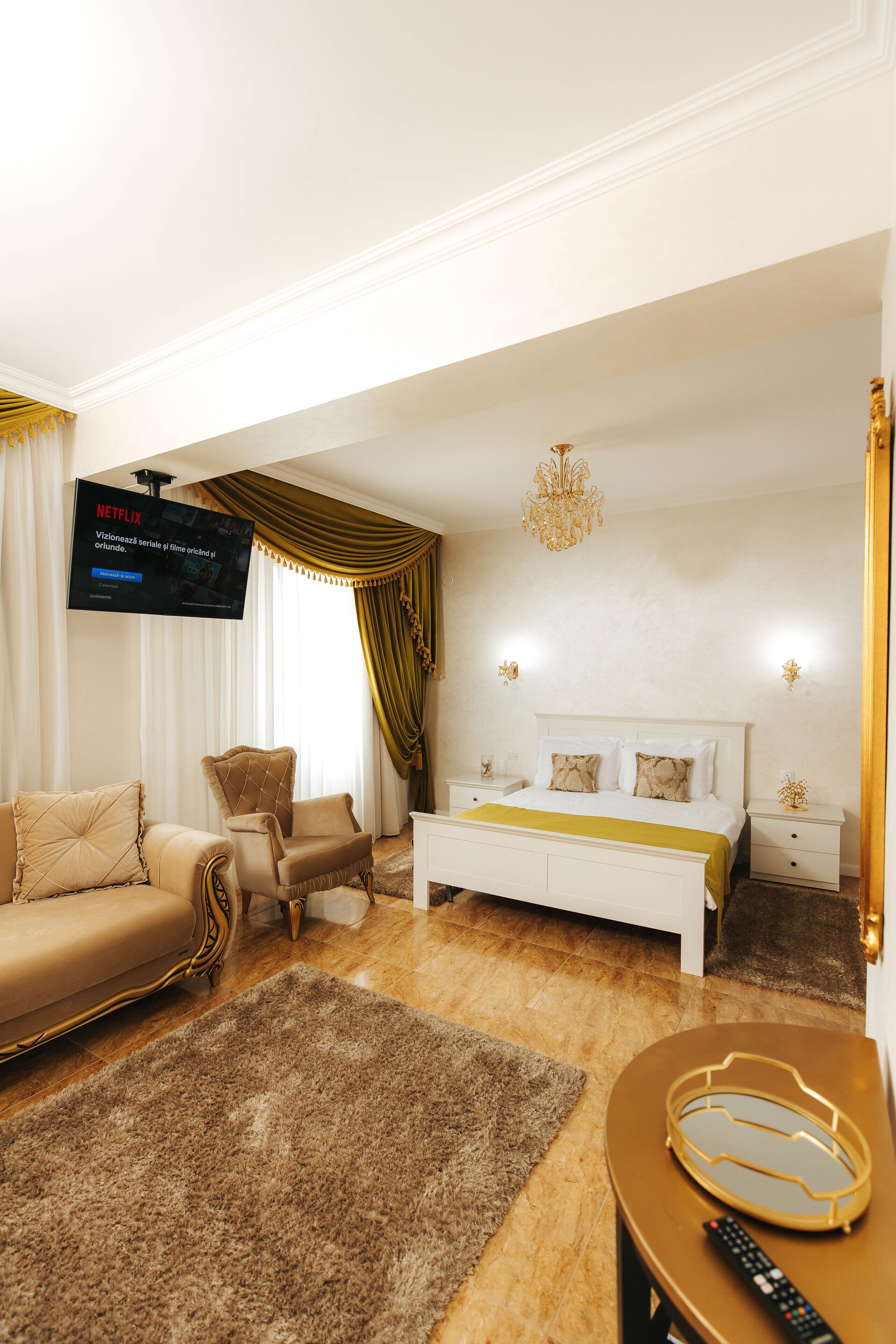 Une chambre moderne équipée d’une télévision, d’un canapé, d’un lit et d’une table de chevet.