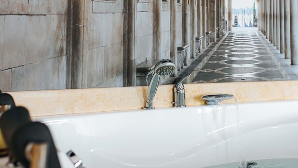 A long corridor with a central water feature, columns, and a reflective ceiling. - Evianne Boutique Hotel (Galati)