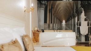 A luxurious bedroom with a large bed, a bathtub, and a mirror reflecting a grand hallway. - Evianne Boutique Hotel (Galati)