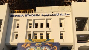 Ismailia Stadium with a large mural of athletes. - Salem Apartment (Ismailia)