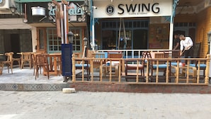 A cafe named SWING with outdoor seating and a brick wall. - Salem Apartment (Ismailia)