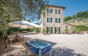 Un bâtiment doté d’une cour, d’un espace extérieur aménagé pour s’asseoir et d’une table de baby-foot.