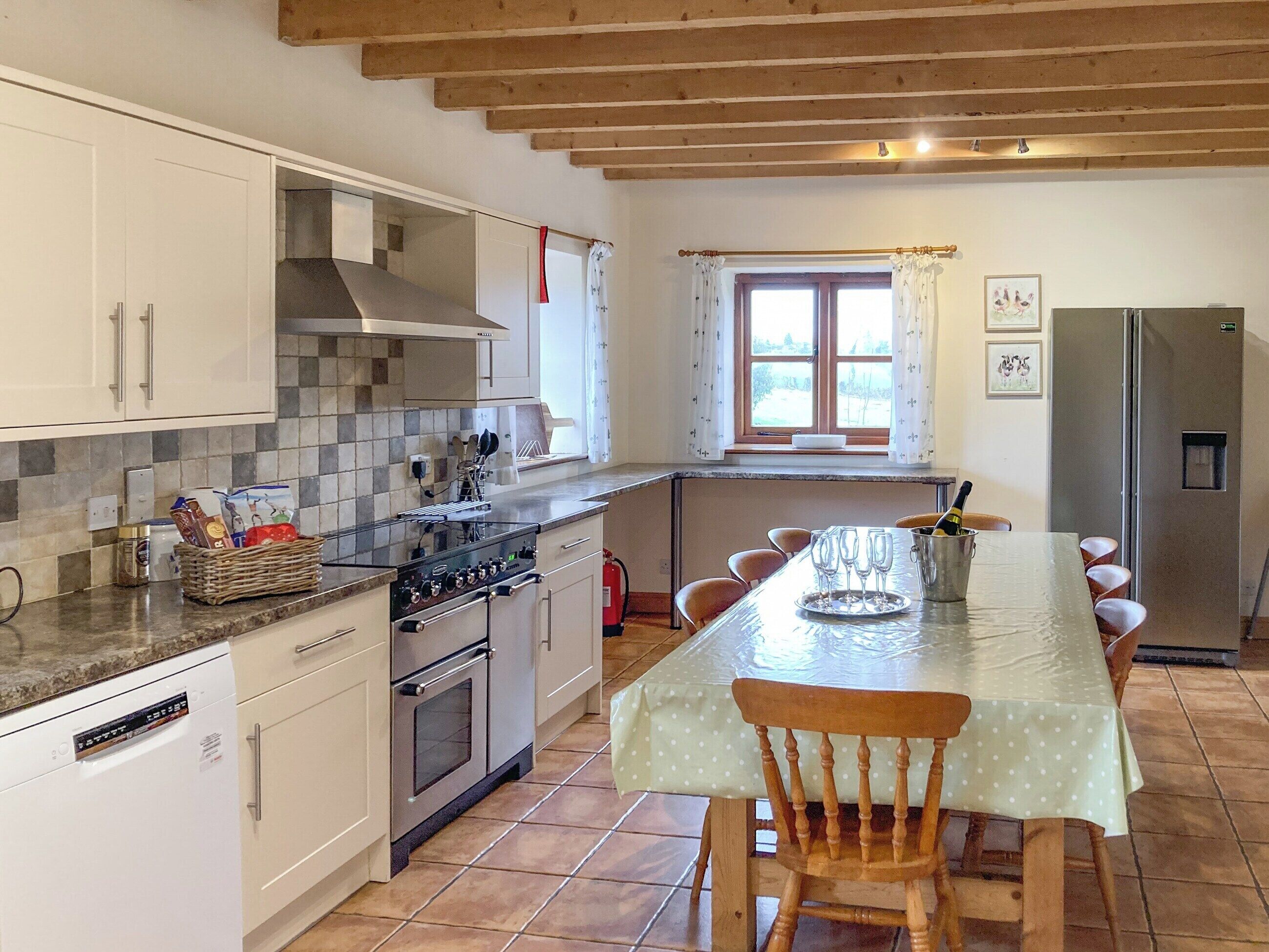 A kitchen with a dining table, chairs, and a refrigerator.
