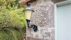 A wall-mounted lamp and a sign reading "Big Barns Cottage".