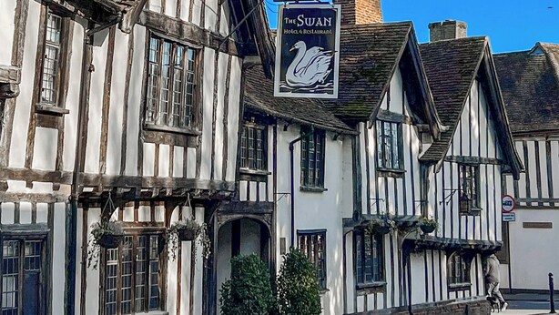 A traditional Tudor-style building with a sign for 'The Swan Hotel & Restaurant'. - Lavenham Red Brick Cottage (Lavenham)