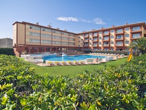 Un hôtel doté d’une piscine, de plusieurs balcons et d’une pelouse bien entretenue.