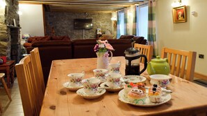 A dining table set with floral tea cups, saucers, and a variety of pastries. - 3 bedroom accommodation in Llangeitho, near Tregaron (Llangeitho, near Tregaron)