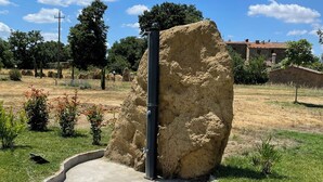 Una gran formació rocosa en una zona acondicionada amb un camí pavimentat que hi convergeix.