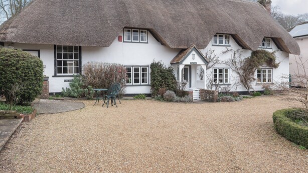 A traditional thatched-roof cottage with a gravel driveway, a small garden, and a sign reading "The Treat". - 1 bedroom accommodation in Nether Wallop, near Stockbridge (Nether Wallop, near Stockbridge)