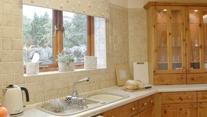 A kitchen with a window, wooden cabinets, a sink, and a kettle. - 3 bedroom accommodation in Newbiggin on Lune, near Kirkby Stephen (Newbiggin on Lune, near Kirkby Stephen)