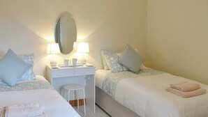A bedroom with two beds, a desk, and a mirror. - 3 bedroom accommodation in Newbiggin on Lune, near Kirkby Stephen (Newbiggin on Lune, near Kirkby Stephen)
