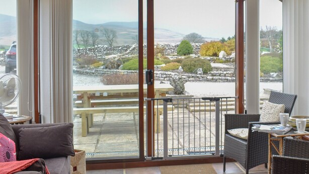 A room with a view of a stone wall and a wooden deck. - 3 bedroom accommodation in Newbiggin on Lune, near Kirkby Stephen (Newbiggin on Lune, near Kirkby Stephen)