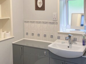 A bathroom with a white sink, a mirror, and a window. - 2 bedroom accommodation in Helmsdale, near Brora (Helmsdale, near Brora)