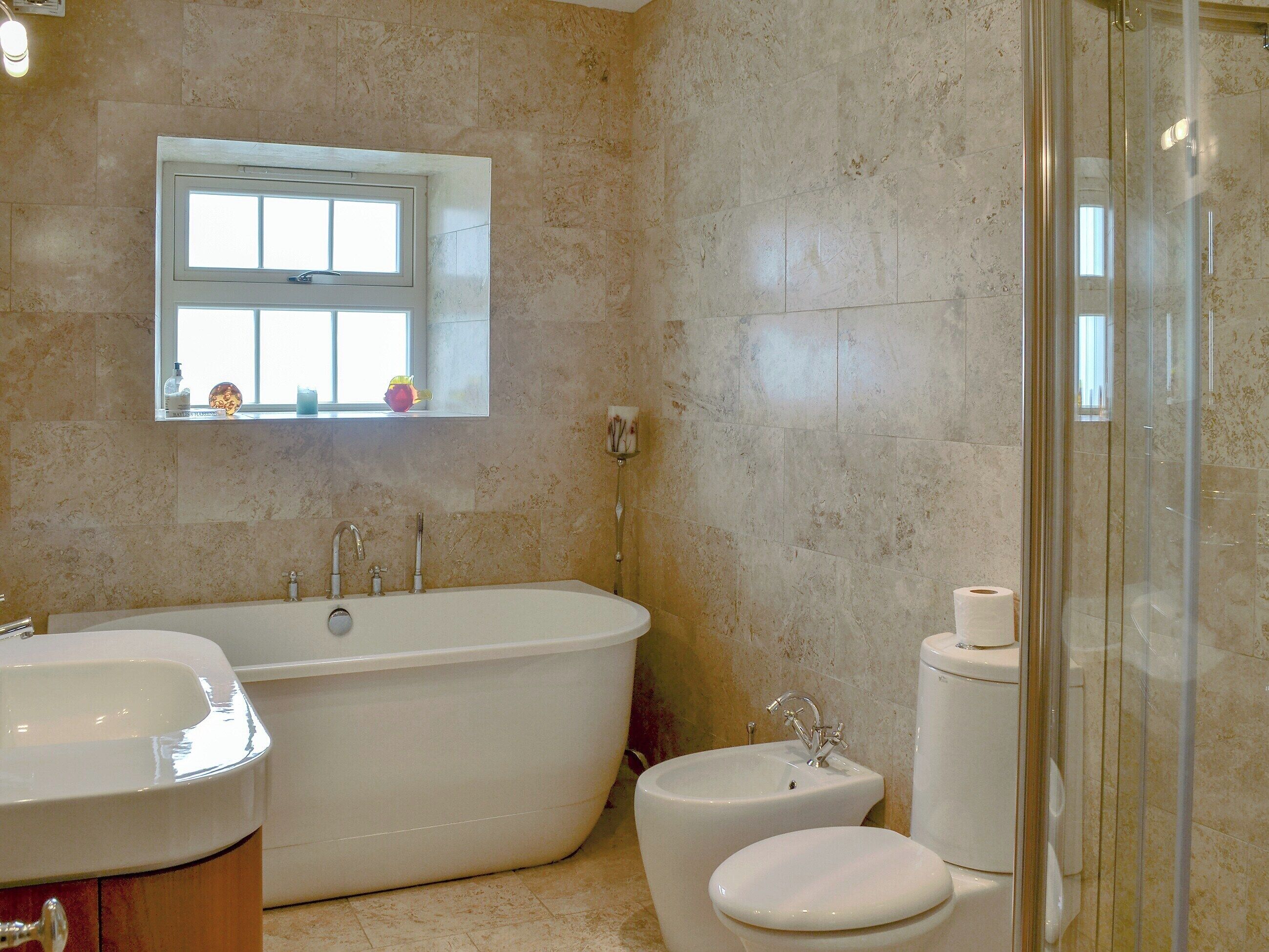 A bathroom with a freestanding bathtub, a toilet, and a sink.
