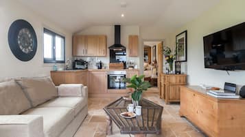 A spacious living area with a sofa, a coffee table, and a TV.