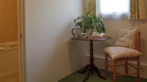 A bathroom with a shower, a small table with a plant, a kettle, and a book. - 1 bedroom accommodation in Lostwithiel (Lostwithiel)