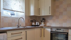 A kitchen with a stainless steel sink, a kettle, a toaster, and a Samsung oven. - 1 bedroom accommodation in Lostwithiel (Lostwithiel)