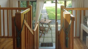 A wooden staircase leading to a patio area with a table and chairs. - 1 bedroom accommodation in Hoe, near Dereham (Hoe, near Dereham)