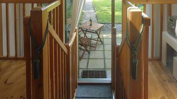 A wooden staircase leading to a patio area with a table and chairs.