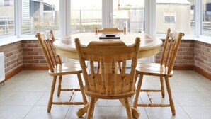 A dining area with a round table and four wooden chairs. - Stable Cottage 3 - UKC3742 (Foxley, near Fakenham)
