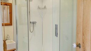 A glass-enclosed shower with a handheld showerhead and a wall-mounted faucet. - Little Barn Tynely Farm (Tynely, near Embleton)