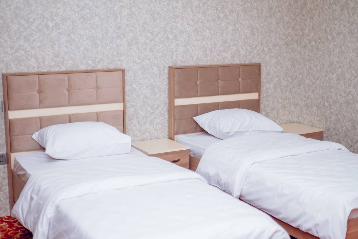 A double bed with a wooden headboard and a nightstand.