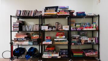 Una estantería llena de juegos de mesa y libros.