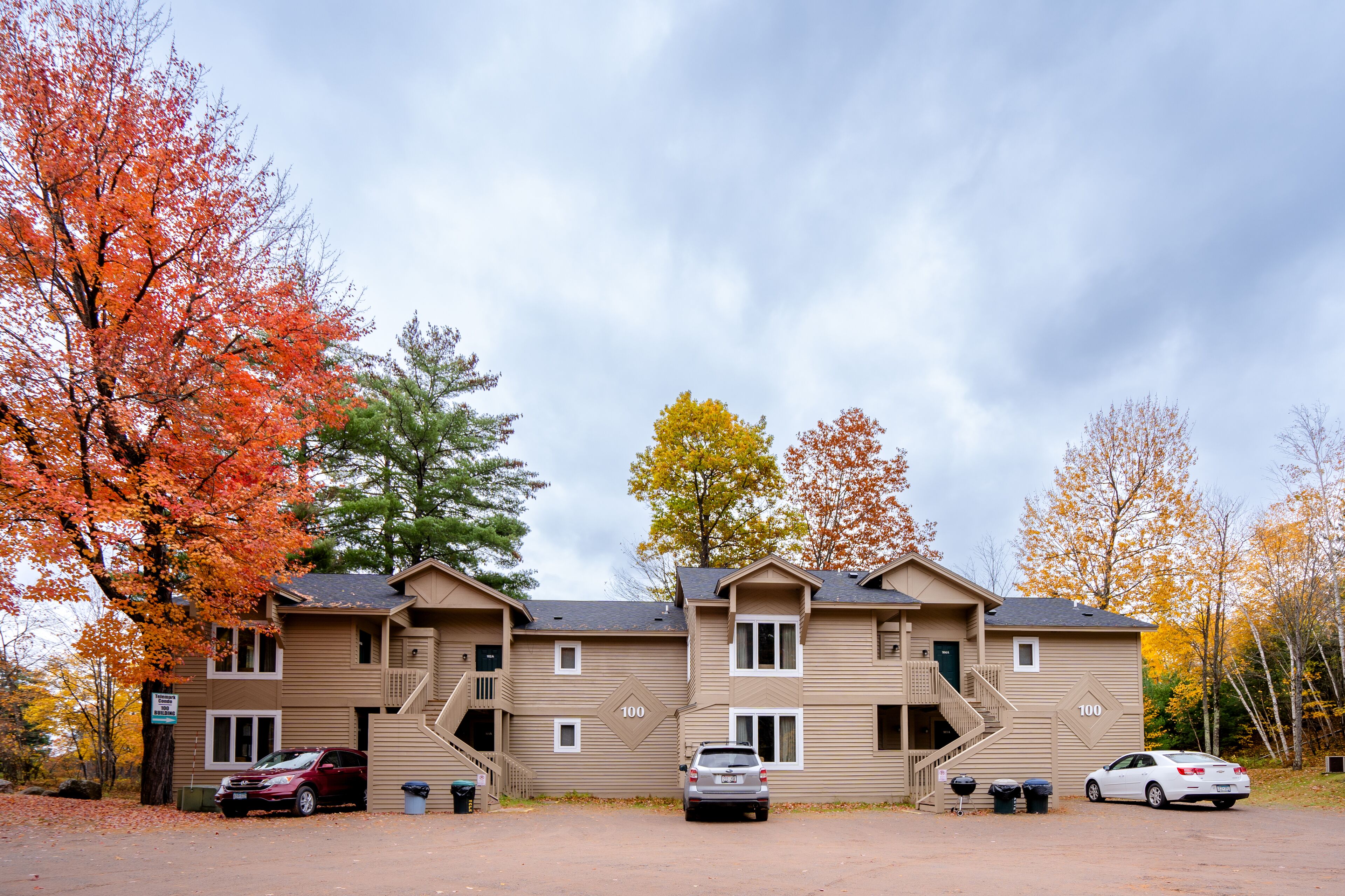 A multi-story building with a parking area in front.