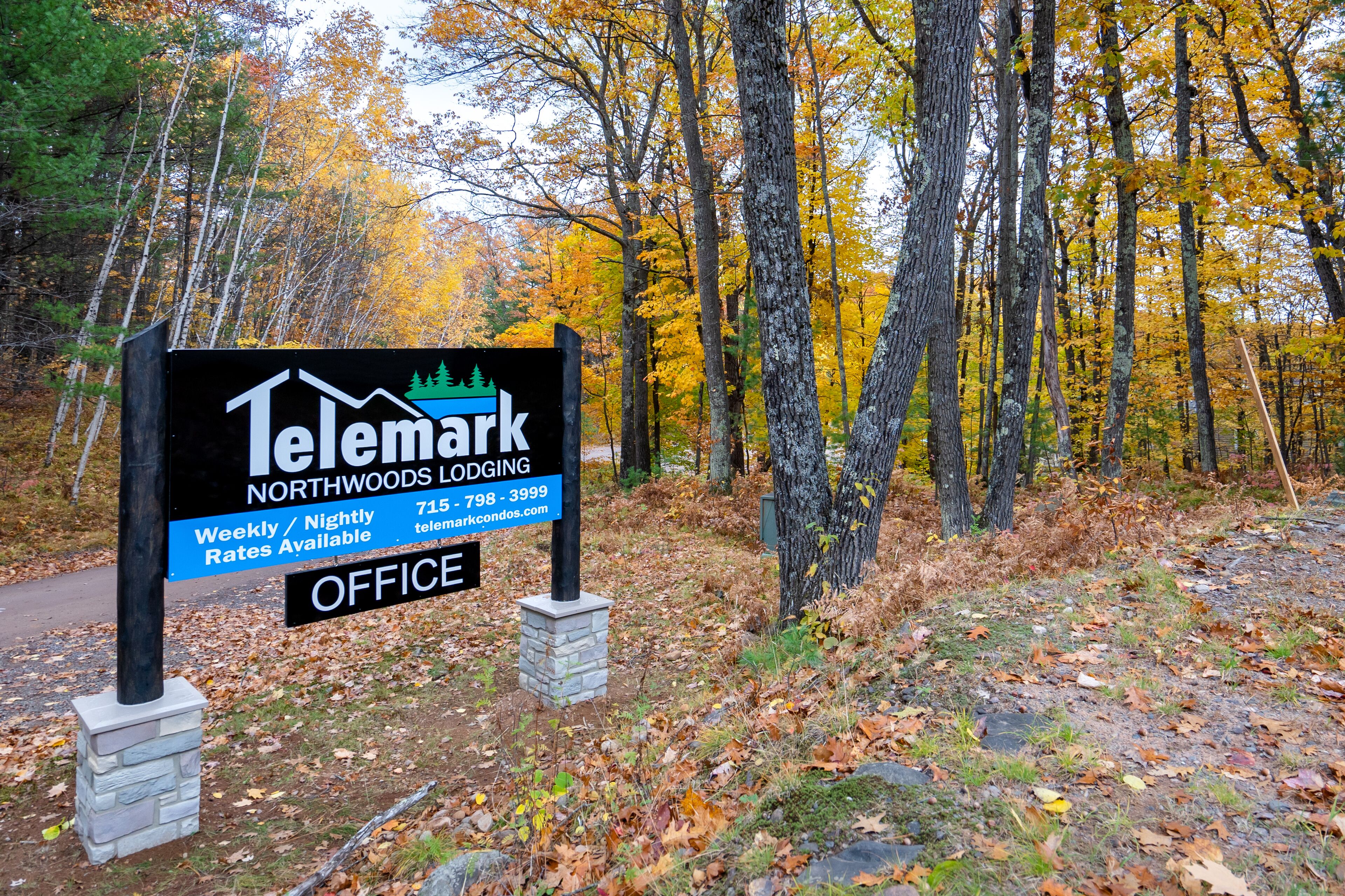 A sign for Telemark Northwoods Lodging with contact information and office availability.