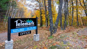 A sign for Telemark Northwoods Lodging with contact information and office availability.