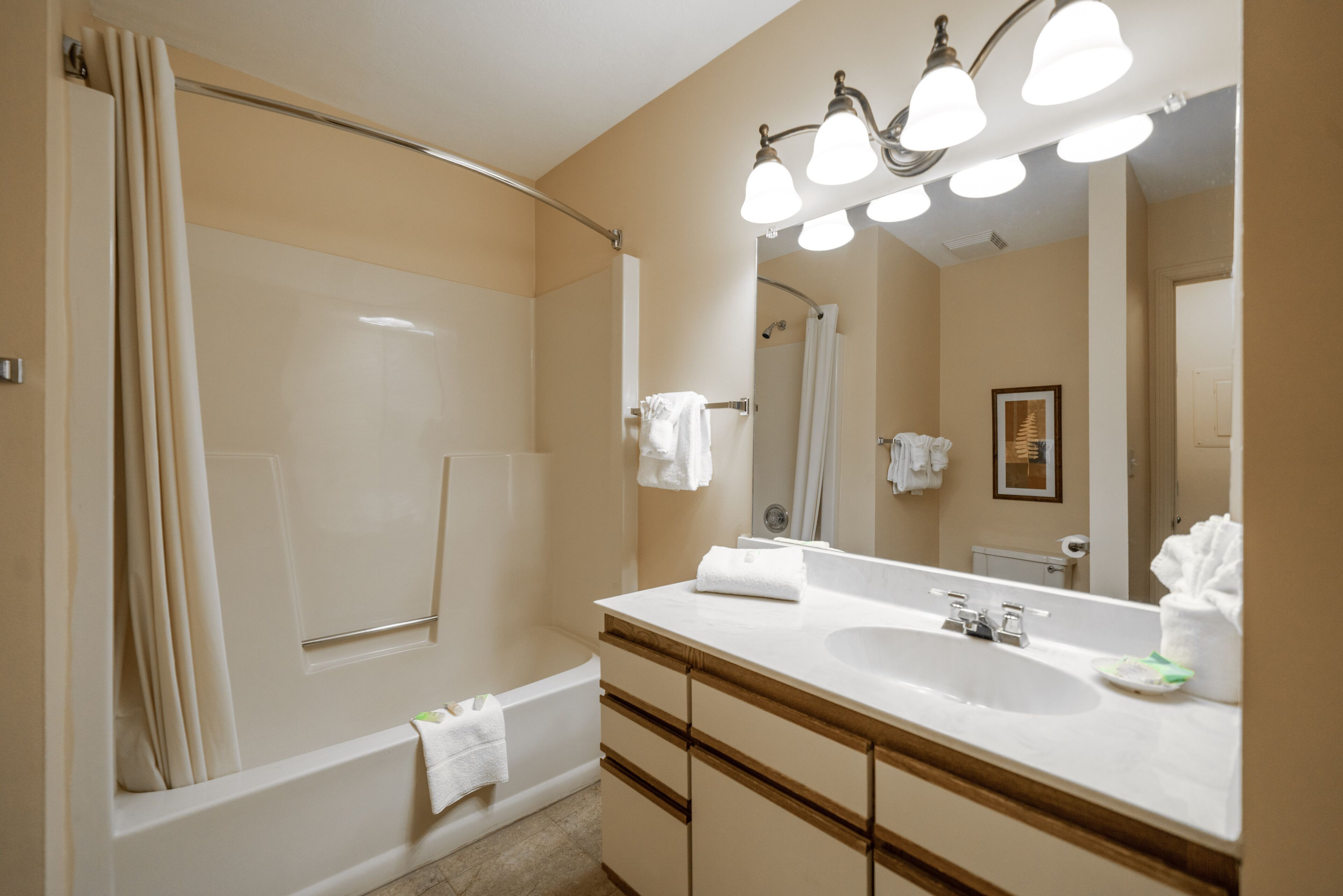 A modern bathroom with a double sink, a bathtub, and a shower.