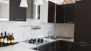Una cocina moderna con armarios oscuros, un lavaplatos de acero inoxidable y una estufa a gas.