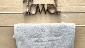 Una toalla colgando en un perchero metálico con la palabra 'Towel' escrita encima.