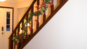 A wooden staircase with a garland of red and gold bows. - Broadmoor Area Home Great for Families and Pets! (Colorado Springs)