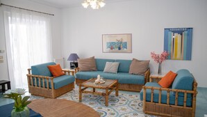 A living room with a blue sofa set, a wooden coffee table, and a patterned floor. - Talè Talè Apartment just 90m from the sandy beach (Marina di Ragusa)