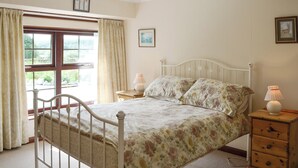 A bedroom with a bed, bedside tables, a window with curtains, and a ceiling light. - Low Cordorcan - UK5891 (Wood of Cree, near Newton Stewart)