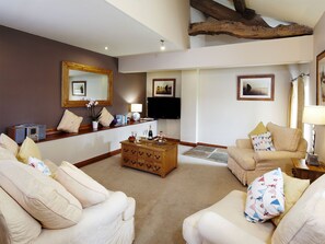 A living room with a sofa, armchairs, a coffee table, a TV, and a fireplace. - Birch Cottage - UK4185 (Millhouse Green, near Penistone)