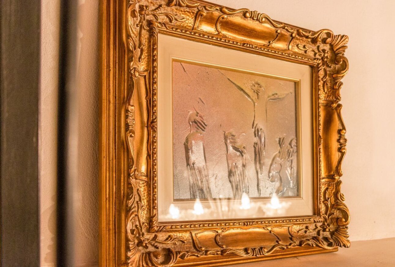 Une œuvre d’art encadrée, avec un cadre doré orné.