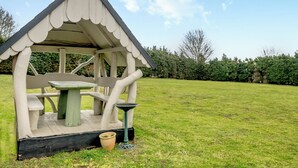 A gazebo with a table and benches, surrounded by a grassy lawn and a hedge. - 1 bedroom accommodation in Horsford, near Norwich (Horsford, near Norwich)