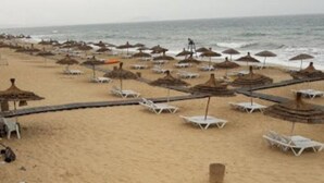 A beach with numerous umbrellas and lounge chairs, indicating a beachside resort setting. - Apartment in Jawhara2 Marina Smir next to the beach with pool. (Tetuán)