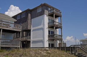 A multi-story building with balconies and a wooden deck.